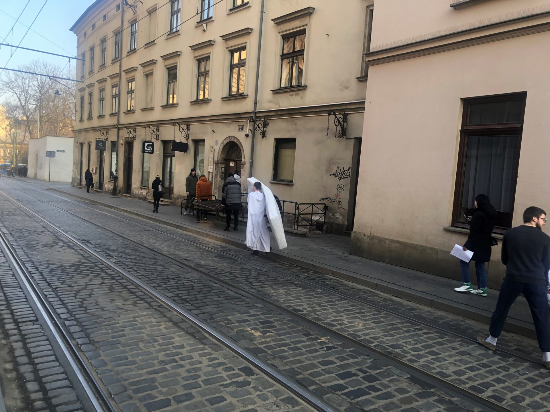 Father Andrzej carries a mattress to an apartment for refugee families