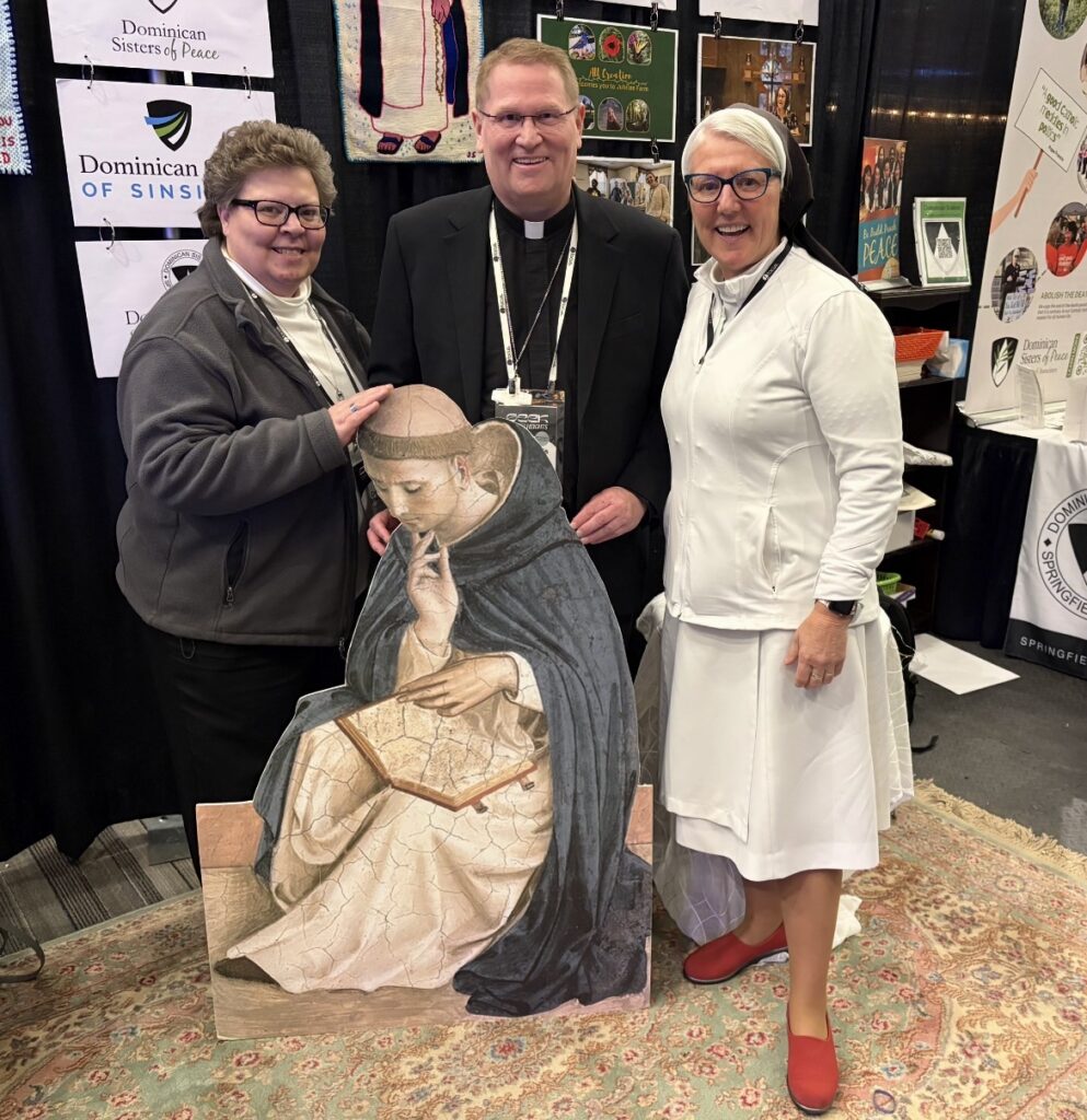 Sisters Denise Glazik and Mary Jo Sobieck stand with BIshop Lousi Tylka and an image of St. Dominic at prayer.