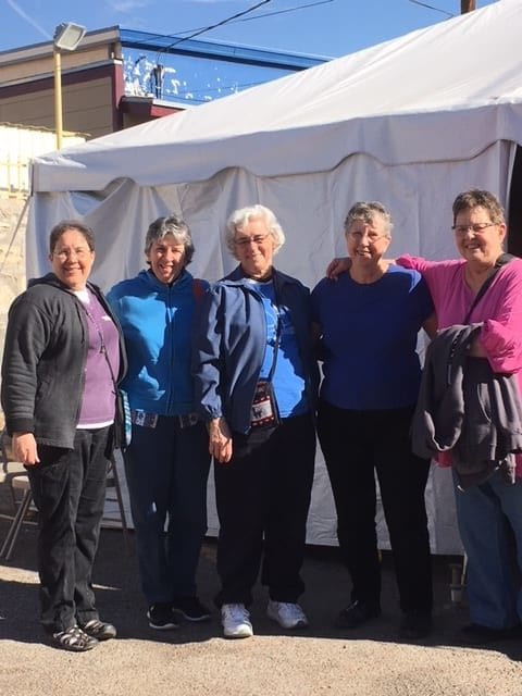 Dominican Sisters Anita Cleary (far left), and Sister Marcelline Koch (center), outside a food tent with friends Julie Wullner, Kathryn Raistrick (on Sister Marcelline's right) and fellow volunteer Sister Betty Baker, CND (next to Sister Anita).