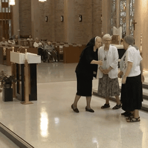 Sister M. Paul McCaughey greetss newly installed council in the Sacred Heart Convent chapel sanctuary.