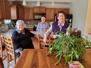 three sisters gathered around their kitchen table